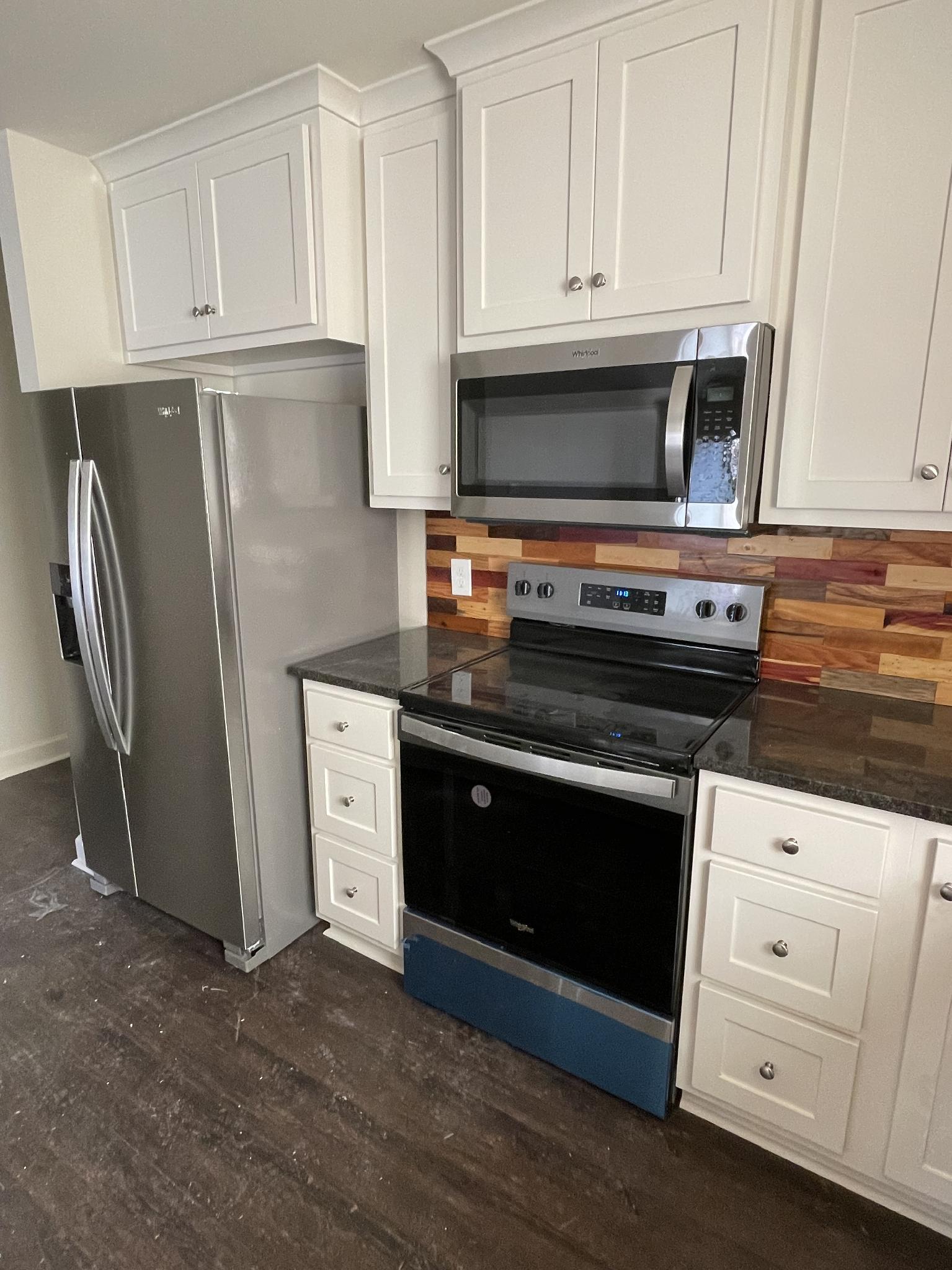 Kitchen with white shaker cabinets and cedar plank backsplash