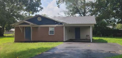 Brick home with carport and blue front doors